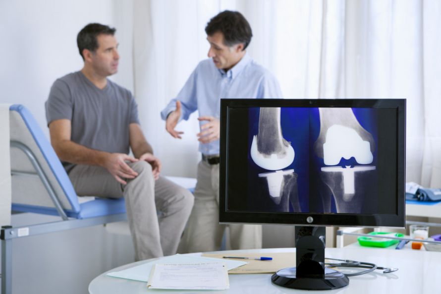 Patient spricht mit Arzt über Knieprothese