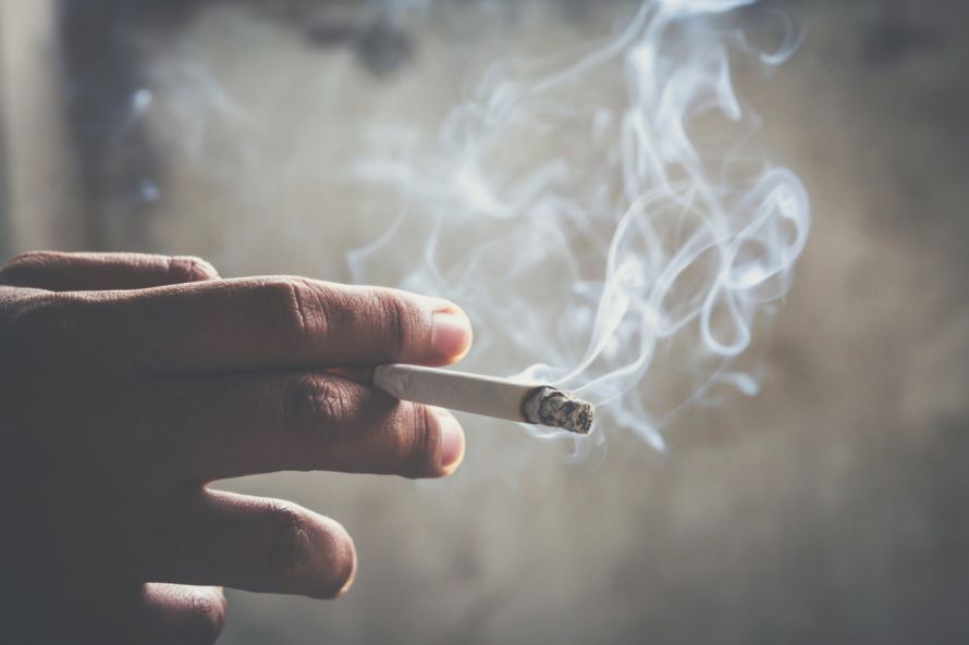 Raucher hält Zigarette in der Hand